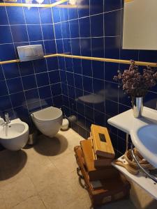 bagno piastrellato blu con servizi igienici e lavandino di Torrebeatrice a Bagnaia