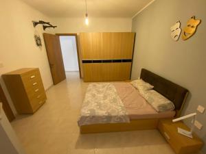 a bedroom with a bed and a dresser and a guitar at Cristina Home in St Paul's Bay