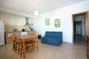 フゼタにあるVilla vista mar e piscinaのキッチン、リビングルーム(テーブル、青い椅子付)