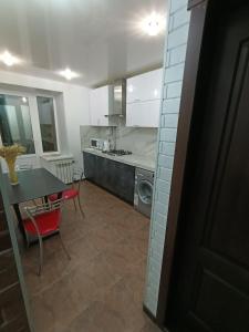 a kitchen and dining room with a table and a dining room at Уютная и просторная квартира в 50 метрах от городского парка in Petropavlovsk