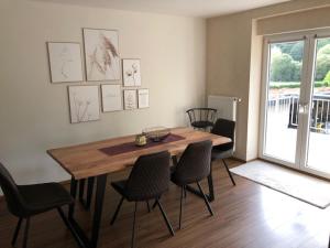 a dining room with a wooden table and chairs at Fiete in Ammerich
