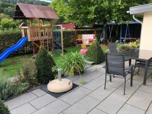 un patio trasero con un parque infantil con mesa y sillas en Fiete en Ammerich