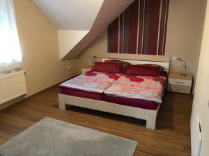 1 dormitorio con 1 cama con almohadas rojas en Fiete en Ammerich
