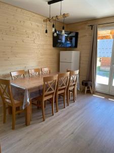 a dining room with a wooden table and chairs at Chalet La joue du Loup in Le Dévoluy