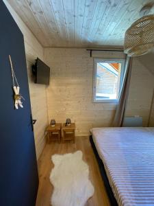 een kamer met een bed, een raam en een deur bij Chalet La joue du Loup in Le Dévoluy