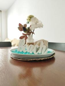 un jarrón con flores en un plato sobre una mesa en Cozy flat with terrace en Palamós