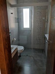 uma casa de banho com um WC, um lavatório e uma janela em Magnifique villa avec piscine em Djerba