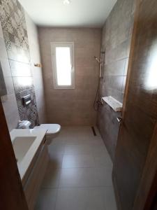 a bathroom with a sink and a tub and a toilet at Magnifique villa avec piscine in Djerba