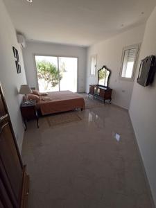 Habitación amplia con cama y espejo. en Magnifique villa avec piscine en Djerba