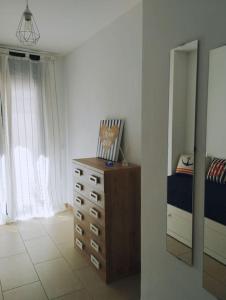1 dormitorio con cama, tocador y espejo en Cozy flat with terrace en Palamós