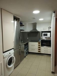 a kitchen with a stainless steel refrigerator and a washer at Cozy flat with terrace in Palamós