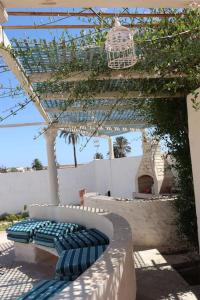 a bench sitting under a pavilion with a bird cage at Magnifique villa avec piscine in Djerba