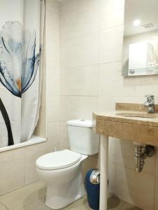 a bathroom with a toilet and a sink at Cozy flat with terrace in Palamós