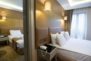 Postel nebo postele na pokoji v ubytování GK Regency Suites Hotel