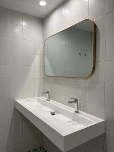 uma casa de banho com um lavatório branco e um espelho. em AZ El Balcón de Conde de Aranda III em Saragoça