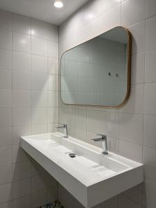 a bathroom with a white sink and a mirror at VTZ El Balcón de Conde de Aranda III in Zaragoza