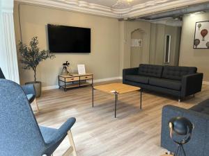 a living room with couches and a flat screen tv at VTZ El Balcón de Conde de Aranda III in Zaragoza