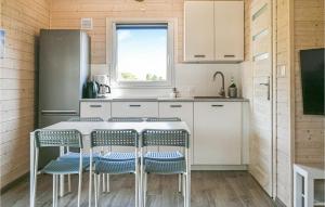 eine Küche mit weißen Schränken und einem Tisch mit Stühlen in der Unterkunft 2 Bedroom Lovely Home In Rewal in Rewal
