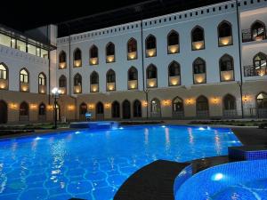 a large swimming pool in front of a building at Rayyan Hotel Samarkand in Samarkand