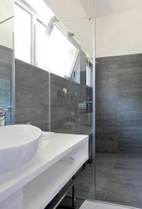 a bathroom with a sink and a glass shower at Apartments & Rooms Lavandula Exclusive in Zadar