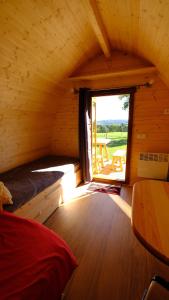 a bedroom with a window in a log cabin at Les Roulottes de la Ferme des Chanaux in Saint-Julien-dʼAnce