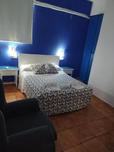 a blue bedroom with a bed and a chair at The Dreamers&Co in Córdoba