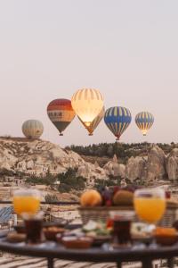 een groep heteluchtballonnen die in de lucht vliegen bij Hera Cave Suites in Goreme