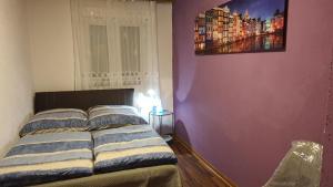 una camera da letto con un letto e un dipinto sul muro di Two-Bedroom Apartment near Triberg Waterfall a Triberg
