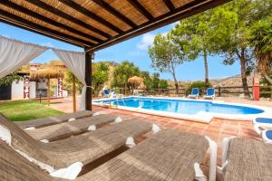 una piscina resort con tumbonas y una piscina en Casa Rural Loma El Letrao en Almogía