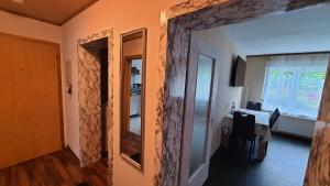 un corridoio con specchio e una stanza con tavolo di Two-Bedroom Apartment near Triberg Waterfall a Triberg