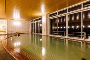 an empty swimming pool in a building with lights at KAMENOI HOTEL Yaizu in Yaizu