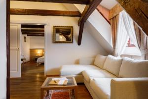 ein Wohnzimmer mit einem Sofa und einem Tisch in der Unterkunft Hotel Historia & Historante in Veszprém