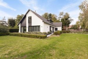 a white house with a large yard at Villa Miro in Sint-Idesbald