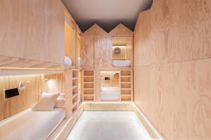 Habitación pequeña con armarios de madera y aseo. en Colo Colo Hostel - Single Private Beds en San Sebastián