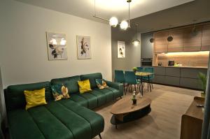 a living room with a green couch and a table at Apartament Witold in Biała Podlaska