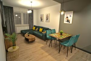 a living room with a green couch and a table at Apartament Witold in Biała Podlaska