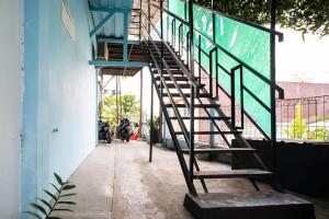 una escalera de caracol en el lateral de un edificio en KoolKost near Margo City Mall en Depok