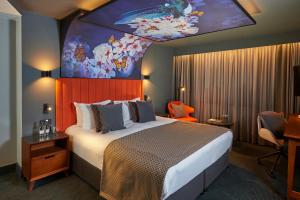 a hotel room with a large bed with a painting on the ceiling at Malmaison Manchester Deansgate in Manchester