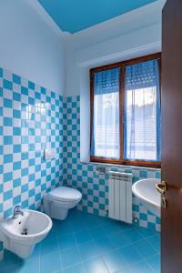a blue tiled bathroom with a toilet and a sink at Il Trabucco e La Terrazza della Val d' Orcia in San Quirico dʼOrcia