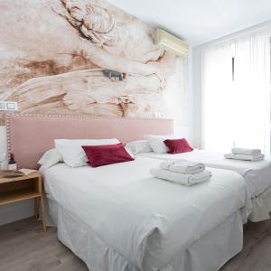 2 camas en un dormitorio con una pintura en la pared en Veracruz Puerta del Sol, en Madrid