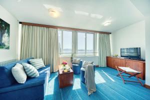 un soggiorno con divano blu e TV di Hotel Kornati a Biograd na Moru