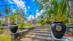 a home with two large vases on the stairs at The Niche by DBI in Hikkaduwa
