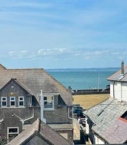 a view of the ocean from the roofs of houses at Lovely big 3 bedroom maisonette close to the beach in Llandudno