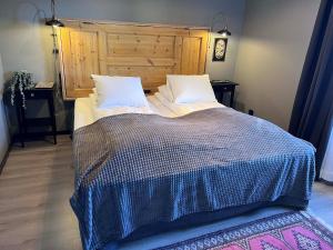 a bedroom with a large bed with a wooden headboard at Hotell Älvdalen in Älvdalen