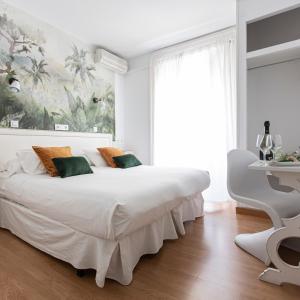 a white bedroom with a large bed and a desk at Veracruz Puerta del Sol in Madrid