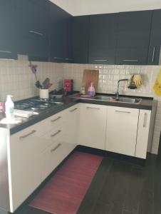 una cocina con armarios blancos y fregadero en benny house en Nettuno