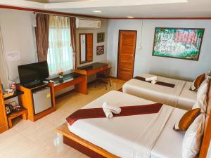 a hotel room with two beds and a flat screen tv at Lanta Paradise Beach Resort in Ko Lanta