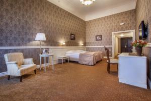 Londonska SPA Hotel في أوديسا: غرفة فندق بها سرير وطاولة وكراسي