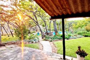 a view of a garden from the porch of a house at Remarkable 3-Bed Cottage in Nyanga in Juliasdale