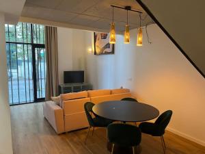 a living room with a couch and a table and chairs at Alameda Velvet, loft en ciudad de las ciencias in Valencia